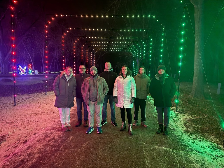 Spies Lab members group photo with holiday lights at the lake